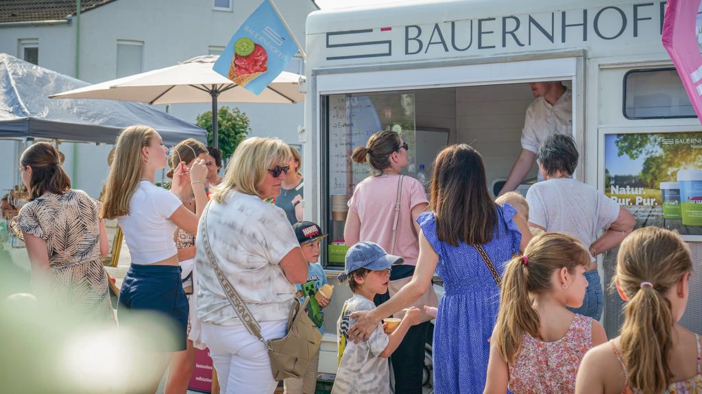 Menschen kaufen Eis am Eiswagen