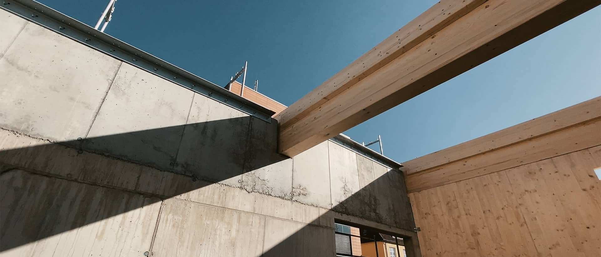 Betonwand, Holz und blauer Himmel